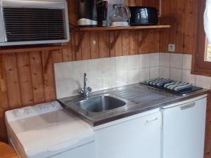 a kitchen with a sink and a microwave at Chalets indépendants avec jardin et jeux d'enfants - FR-1-489-402 in Mesples
