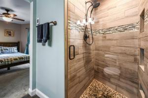 a bathroom with a shower with a wooden wall at Distiller's Den in Gatlinburg +17 photos
