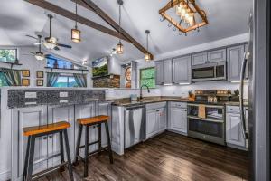 a kitchen with white cabinets and two bar stools at Distiller's Den in Gatlinburg
