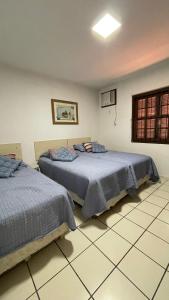 zwei nebeneinander stehende Betten in einem Schlafzimmer in der Unterkunft Casa de Praia - 4 quartos Centro in Bombinhas
