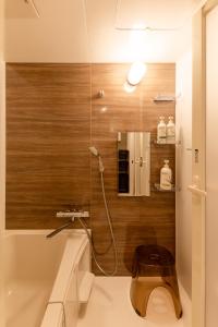 a bathroom with a shower with a wooden wall at The Residence Sapporo - すすきの駅から徒歩6分 - in Sapporo