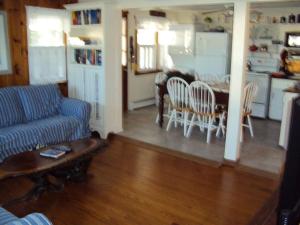 Ocean Side Home In Brant Beach 36525 في Brant Beach: غرفة معيشة مع أريكة وطاولة ومطبخ