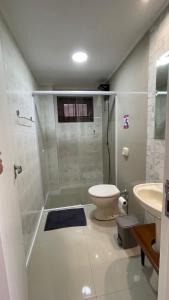 ein Badezimmer mit Dusche, Toilette und Waschbecken in der Unterkunft Casa de Praia - 4 quartos Centro in Bombinhas