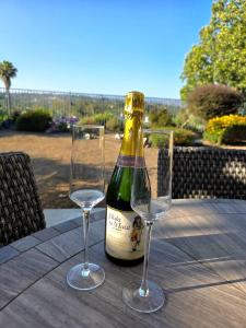 uma garrafa de vinho e duas taças sobre uma mesa em Modern Residence with Mountain Views em Escondido