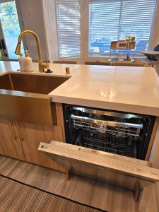 uma máquina de lavar louça aberta numa cozinha com um lavatório em Modern Residence with Mountain Views em Escondido