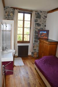 una camera da letto con lavandino, letto e finestra di Les Ondines a Gembrie