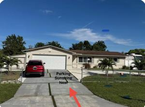 Una casa con un cartel de estacionamiento soleado frente a ella. en Sunshine Nest, en Lehigh Acres