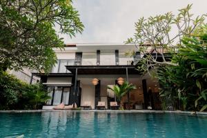 una casa con piscina di fronte a un edificio di Dawn Villa Canggu a Canggu