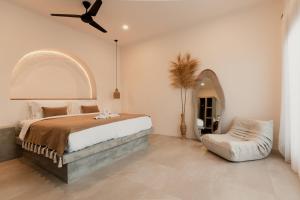 una camera da letto con un letto e un ventilatore a soffitto di Dawn Villa Canggu a Canggu