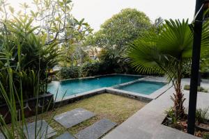 una piscina in un giardino con piante di Dawn Villa Canggu a Canggu Altre 17 foto
