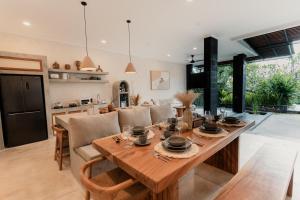 una cucina e una sala da pranzo con tavolo e sedie in legno di Dawn Villa Canggu a Canggu