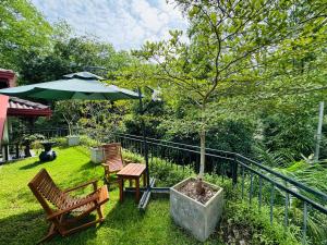 a patio with two chairs and a table and an umbrella at Heavenly Hideaway in Tangalle