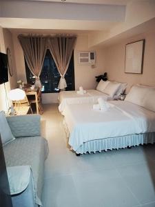 ein Hotelzimmer mit zwei Betten und einer Couch in der Unterkunft The Purffect Nook Your home away from home in Mandaue City