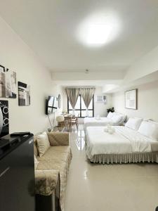ein Hotelzimmer mit zwei Betten und einer Couch in der Unterkunft The Purffect Nook Your home away from home in Mandaue City