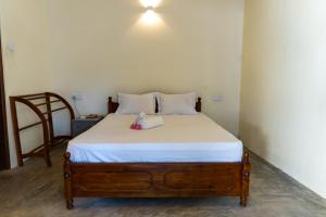 een bed met daarop een knuffeldier bij Margosa Ahangama in Ahangama