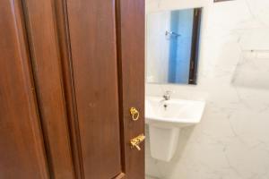 een badkamer met een houten deur en een wastafel bij Margosa Ahangama in Ahangama +10 foto's