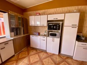 a kitchen with white cabinets and a microwave at Hostal Nuevo Sol y Viento in San Pedro de Atacama +52 photos