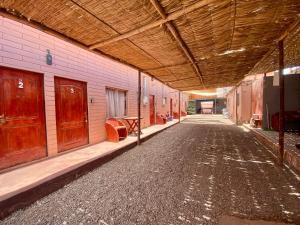 an empty hallway of a building with a wooden ceiling at Hostal Nuevo Sol y Viento in San Pedro de Atacama