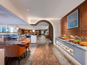 un restaurante con mesa y comedor en Novotel Shanghai Baoshan Jiusi, en Shanghái