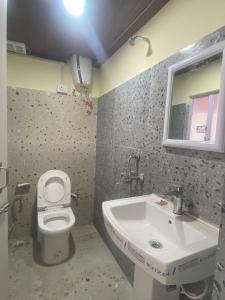 a bathroom with a toilet and a sink at 12 Degree in Takdāh