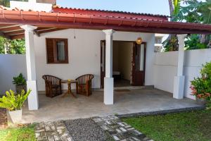 een terras met stoelen en een tafel voor een huis bij Margosa Ahangama in Ahangama