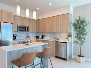 uma cozinha com uma ilha com cadeiras e uma planta em Desing district, great apartment em Miami