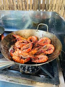 Puerto idilio beach resort في Isla Larga: مقلاة مليئة بالروبيان تُطهى على الشواية