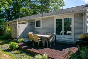 Minutes to Craigville Beach Private Patio and Backyard في بارنستابل: فناء مع طاولة وكراسي أمام المنزل