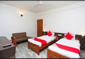 a hotel room with two beds and a desk and a desk at Hotel Vijay Palace in Bhopal