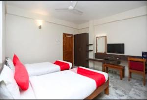 a hotel room with two beds and a television at Hotel Vijay Palace in Bhopal
