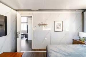 a bedroom with white walls and a bed and a desk at Overlooking a Park - A sunny escape in Rooty Hill