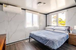 a bedroom with a bed and two windows at Overlooking a Park - A sunny escape in Rooty Hill +28 photos