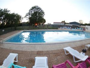 Mobil-home confortable pour 5 pers. en camping à Payrac - API-1-52-1221 في Payrac: مسبح حوله كراسي جلوس