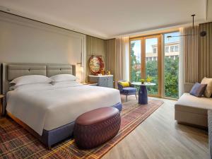Un dormitorio con una cama grande y un sofá. en Fairmont Hanoi, en Hanói 83 fotos más