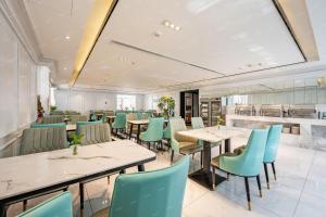 ein Restaurant mit weißen Tischen und blauen Stühlen in der Unterkunft Manyueju Hotel 