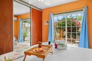 a living room with orange walls and a table at Palma Azul- Dushi Bida in Palm-Eagle Beach