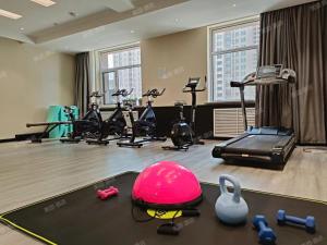 ein Fitnessstudio mit Laufbändern und Trainingsgeräten in einem Raum in der Unterkunft Manyueju Hotel 