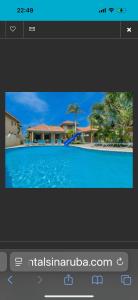 a television screen with a picture of a swimming pool at Palma Azul- Dushi Bida in Palm-Eagle Beach