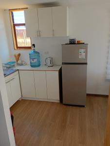 una piccola cucina con frigorifero e armadietti bianchi di Cabañas Campo y Mar a Los Corrales Altre 5 foto