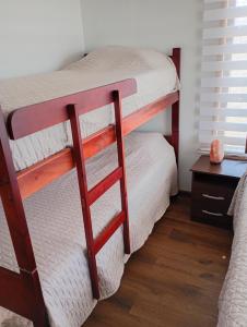 Cabañas Campo y Mar في Los Corrales: سريرين بطابقين في غرفة مع طاولة