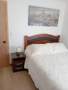 Cabañas Campo y Mar في Los Corrales: غرفة نوم بها سرير ولوحة على الحائط