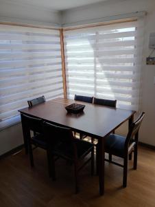 Cabañas Campo y Mar في Los Corrales: طاولة وكراسي في غرفة بها نوافذ +3 صور