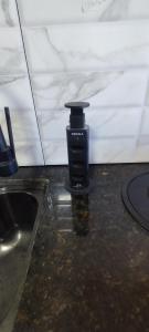 a black bottle sitting on a counter next to a sink at Casa Brisa ar condicionado excelente banho a gás e acabamento premium próximo ao mar in Imbé +18 photos