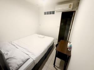 a small bedroom with a bed and a small table at zNAP - Khaosan Road สแนป ตรอกข้าวสาร in Bang Bua Thong Railway Station