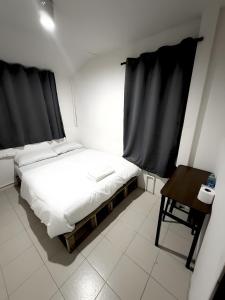 a small bedroom with a bed and a table at zNAP - Khaosan Road สแนป ตรอกข้าวสาร in Bang Bua Thong Railway Station