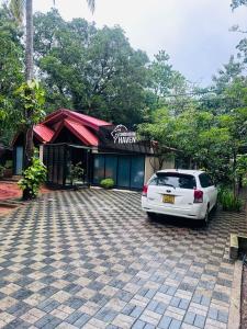 a white car parked in front of a building at Singhagiri Haven Sigiriya in Sigiriya