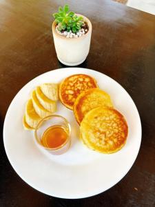 カオソックにあるSP House Khao Sokのパンケーキとシロップの入ったボウルが置かれた白い皿