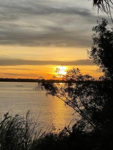 un coucher de soleil sur une grande étendue d'eau dans l'établissement Home Stay 1, à Kratie