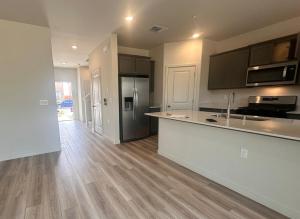 Una cocina vacía con encimera y refrigerador. en A modern retreat and Gateway to Yosemite, en Merced