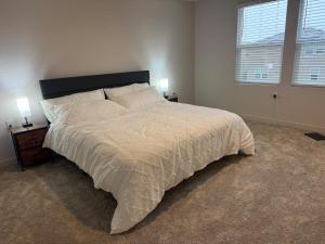 Un dormitorio con una gran cama blanca con dos lámparas. en A modern retreat and Gateway to Yosemite, en Merced